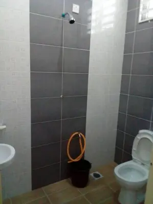a bathroom with a shower with a toilet and a sink at Percutian Di Taiping & Bukit Merah Laketown in Kamunting