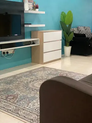 a living room with a tv and a rug at Homestay Desa Tikam batu in Sungai Petani