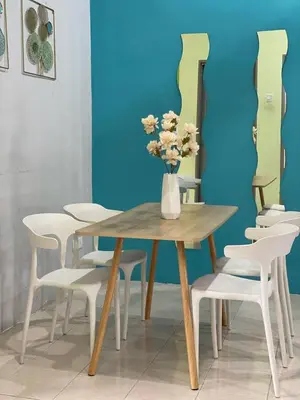 a table with white chairs and a vase with flowers at Homestay Desa Tikam batu in Sungai Petani
