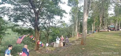 a group of people sitting in a park at Homestay Desa Tikam batu in Sungai Petani