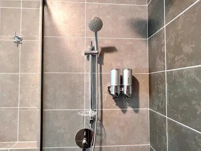 a shower with a microphone on a tiled wall at 2-8pax Ipoh Nomado Onsen suites by Sunway Onsen Lost world of Tambun in Ipoh
