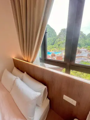 a bed with white pillows in a room with a window at 2-8pax Ipoh Nomado Onsen suites by Sunway Onsen Lost world of Tambun in Ipoh