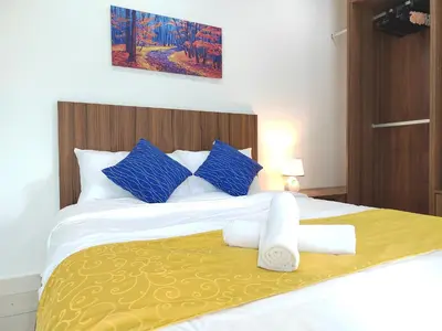 a bedroom with a large bed with blue and white pillows at Exclusive Studio/15th/ 1~4pax/ Gurney/ Mansion One in George Town