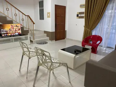 a living room with two chairs and a red chair at Comfy Sutera Seberang Jaya in Kampong Belah Dua