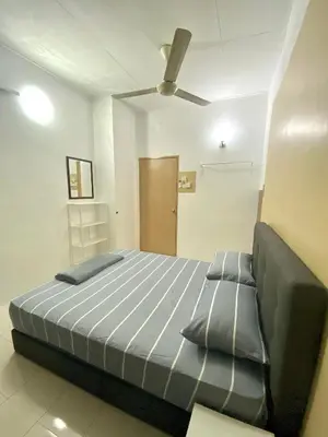 a bedroom with a bed and a ceiling fan at Comfy Sutera Seberang Jaya in Kampong Belah Dua