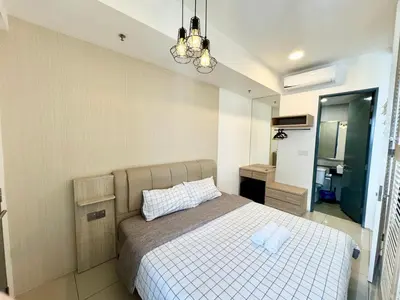a bedroom with a bed and a sink and a mirror at Tropicana 218 Macalister by CC in George Town