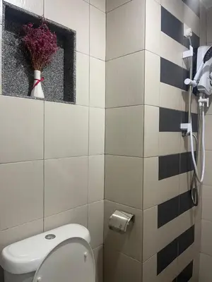 a bathroom with a toilet and a window and flowers at Trails of Kampar in Kampar