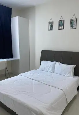 a bedroom with a large bed with white sheets at Trails of Kampar in Kampar