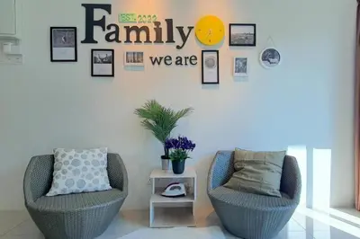 a living room with two chairs and a sign that reads family we are at Ipoh Meru Landed Semi D with Barbeque for 12 Pax in Ipoh