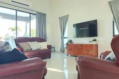 a living room with two couches and a flat screen tv at Ipoh Meru Landed Semi D with Barbeque for 12 Pax in Ipoh