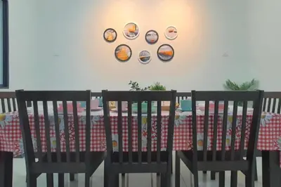 a dining room table with two chairs and plates on the wall at Ipoh Meru Landed Semi D with Barbeque for 12 Pax in Ipoh