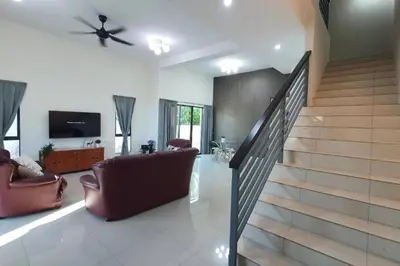 a living room with a couch and a staircase at Ipoh Meru Landed Semi D with Barbeque for 12 Pax in Ipoh