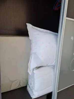 a stack of white pillows on a bunk bed at 3Storey House 13Pax Family Suite in Bayan Lepas
