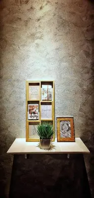 a table with three pictures and a potted plant on it at IPOH AGONG HOMESTAY by ONE LIFE FOUR SEASON GUESTHOUSE in Ipoh