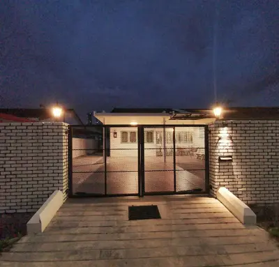 a building with a gate with lights on it at IPOH AGONG HOMESTAY by ONE LIFE FOUR SEASON GUESTHOUSE in Ipoh