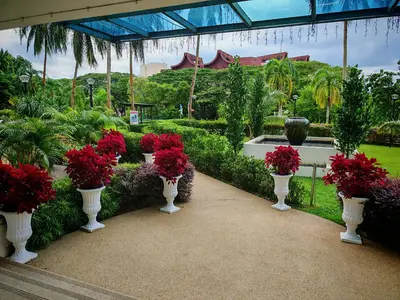 a garden with white vases filled with red flowers at Sri Sayang Home Stay in George Town