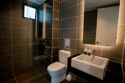 a bathroom with a toilet and a sink and a mirror at Ipoh Tambun Lost World Sunway Onsen Suite 2R 8Pax Mira Theme Park View in Ipoh