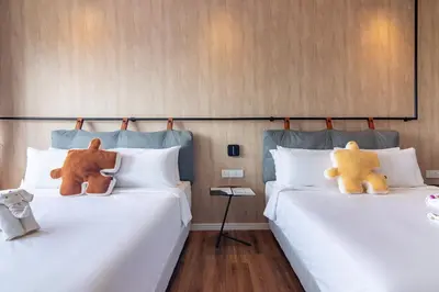 two beds with teddy bears sitting on top of them at Bagan Suite in Butterworth
