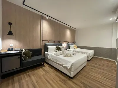 a hotel room with two beds and a couch at Bagan Suite in Butterworth