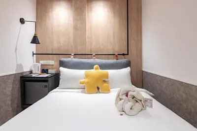 a yellow teddy bear sitting on top of a bed at Bagan Suite in Butterworth