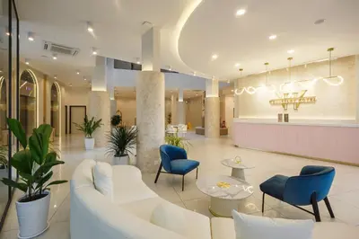 a lobby with a white couch and blue chairs at Wellesley Hotel in Simpang Ampat