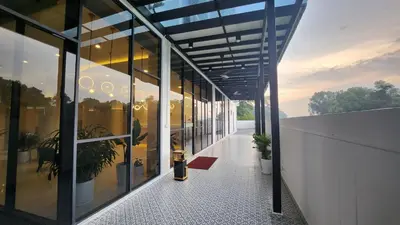 a building with glass windows and a walkway at Wellesley Hotel in Simpang Ampat