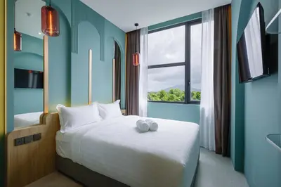 a bedroom with a large bed with a window at Wellesley Hotel in Simpang Ampat