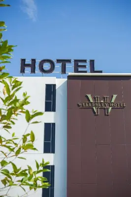 a hilton sign on the side of a building at Wellesley Hotel in Simpang Ampat