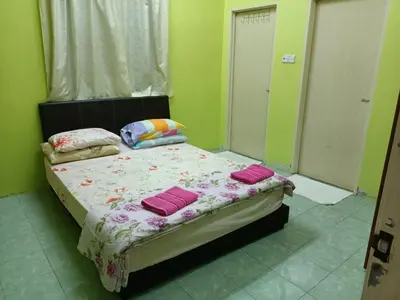 a bedroom with a bed with pink pillows on it at HOMESTAY JANNATI TAMBUN in Tambun
