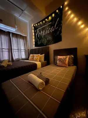 a living room with two beds and a sign on the wall at Room1#IG theme Bargainous#Shared Bathroom#3pax#2min Kek Lok Si in Ayer Itam