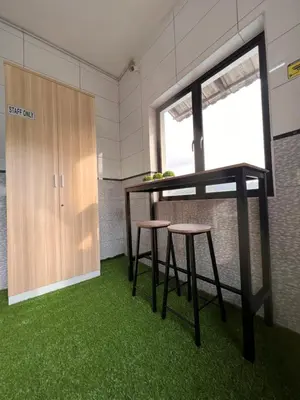 a table and two stools in a room with green carpet at Room2#IG theme Bargainous#Shared Bathroom#4pax#2min Kek Lok Si in Ayer Itam