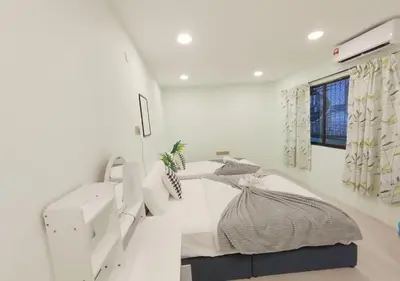 a white room with a bed and a desk at Dim Sum Homestay in Ipoh