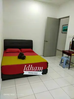a bed in a room with a yellow and red blanket at Idham homestay 2 in Ipoh