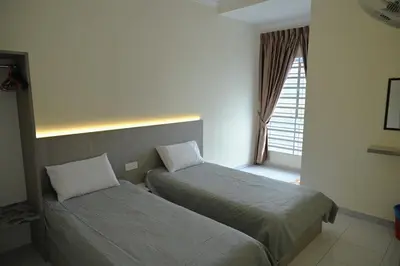 a hotel room with two beds and a window at Emerald Avenue Apartment Madam Ng. in Cameron Highlands