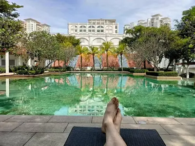 a person laying on a mat in front of a swimming pool at Perfect Marina Stay@ Strait Quay 5 pax w/ Free Carpark in Bagan Jermal