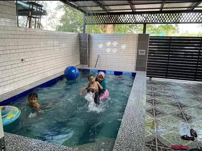 two children playing in an indoor swimming pool at Homestay Idaman Private Pool Mslim in Kuala Kangsar