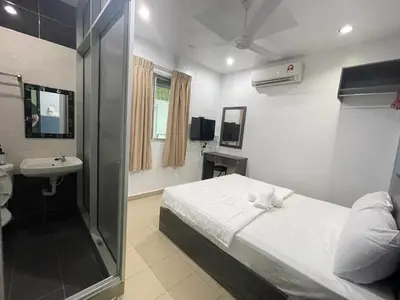 a bedroom with a bed and a sink and a mirror at MR Homestay HotelStyle Room Teluk Intan in Teluk Intan