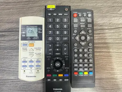 two remote controls sitting next to each other on a table at MR Homestay HotelStyle Room Teluk Intan in Teluk Intan
