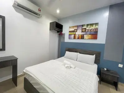 a bedroom with a white bed and a painting on the wall at MR Homestay HotelStyle Room Teluk Intan in Teluk Intan