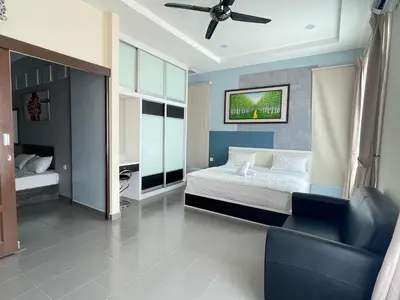 a bedroom with a bed and a couch and a ceiling fan at MR Homestay HotelStyle Room Teluk Intan in Teluk Intan