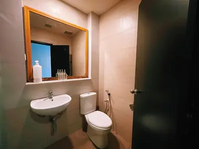a bathroom with a toilet and a sink and a mirror at NOVA Apartment at Cameron in Cameron Highlands