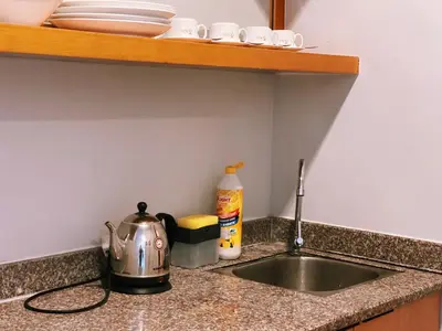a kitchen sink with a tea kettle and plates on a shelf at NOVA Apartment at Cameron in Cameron Highlands