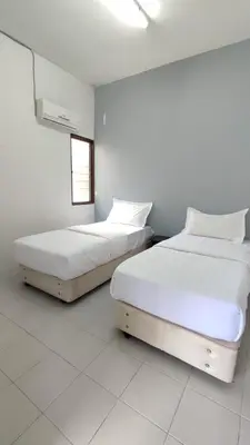 two beds sitting next to each other in a room at Pusing Holiday Apartment in Pusing