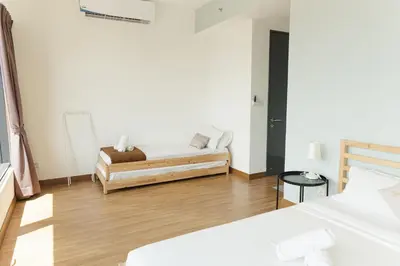 a bedroom with two beds and a couch in it at The CEDAR, 2BR Cityview by WStay @ Tropicana 218 Macalister in George Town