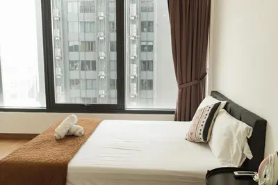 a bed with a stuffed animal on it in a room with windows at The CEDAR, 2BR Cityview by WStay @ Tropicana 218 Macalister in George Town