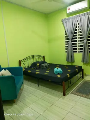 a bedroom with a bed and a blue couch at Homestay Haji Din Tronoh Perak in Teronoh