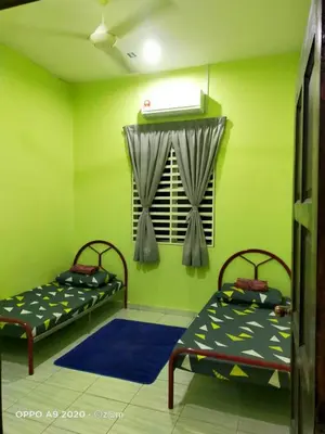 two beds in a room with green walls at Homestay Haji Din Tronoh Perak in Teronoh