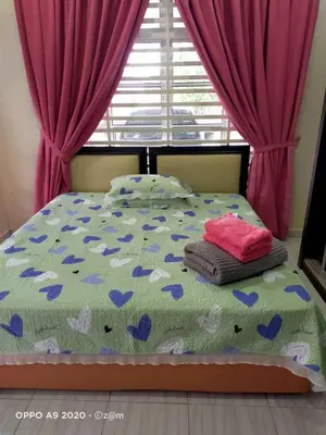 a bedroom with a bed with purple curtains at Homestay Haji Din Tronoh Perak in Teronoh