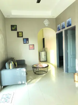 a living room with a couch and a table at Fidaiy Homestay in Teronoh
