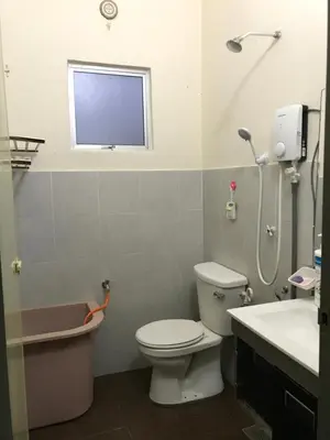 a bathroom with a toilet and a sink and a window at Fidaiy Homestay in Teronoh